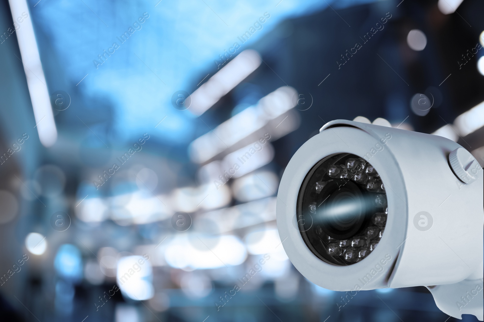 Image of Modern security CCTV camera against blurred background, space for text