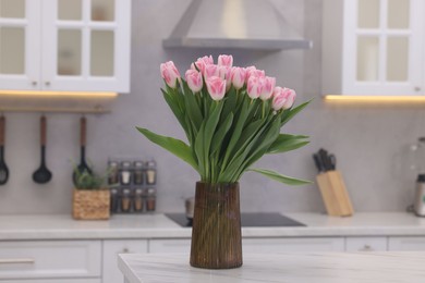 Photo of Beautiful bouquet of fresh pink tulips on table in kitchen