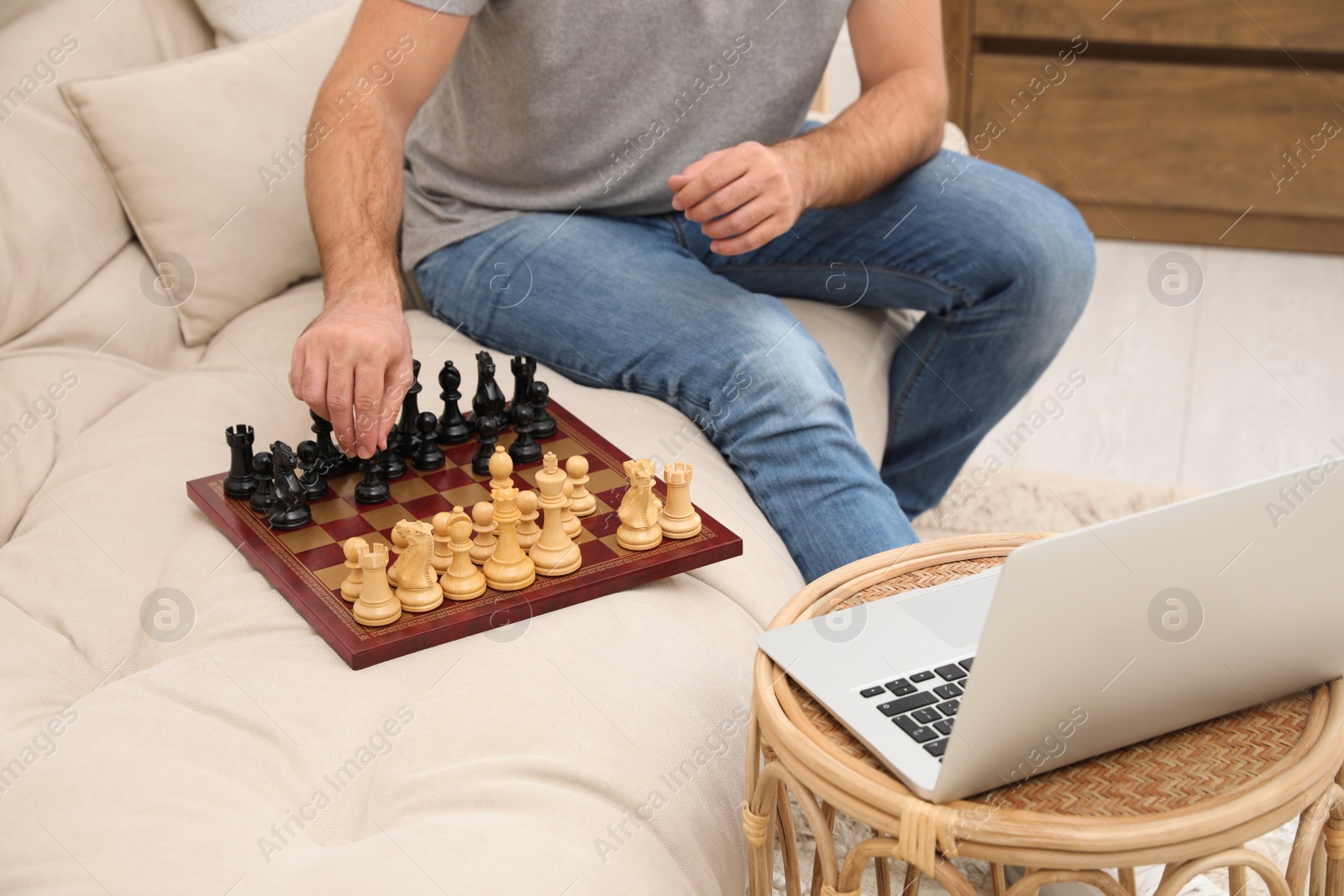 Photo of Man playing chess with partner through online video chat at home, closeup