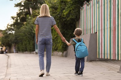 Photo of Woman and her little son on their way to kindergarten outdoors