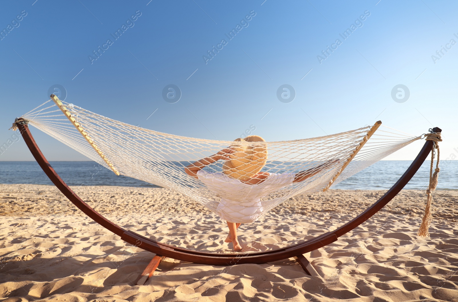 Photo of Young woman relaxing in hammock on beach