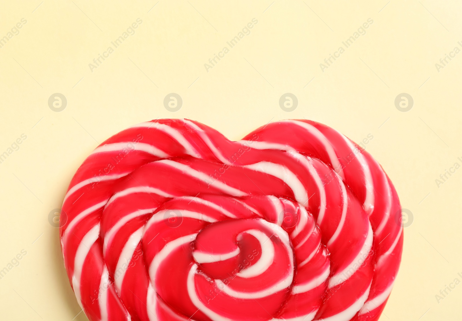Photo of Sweet heart shaped lollipop on beige background, top view. Valentine's day celebration