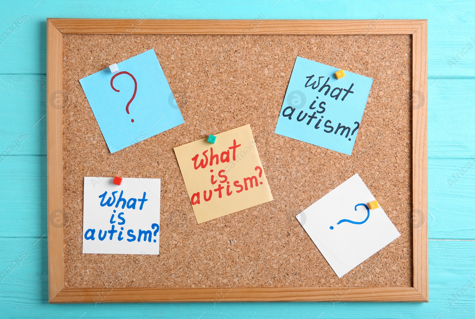 Photo of Notes with words WHAT IS AUTISM on cork board