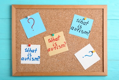 Photo of Notes with words WHAT IS AUTISM on cork board