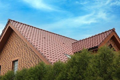 Photo of Beautiful house with red roof against blue sky