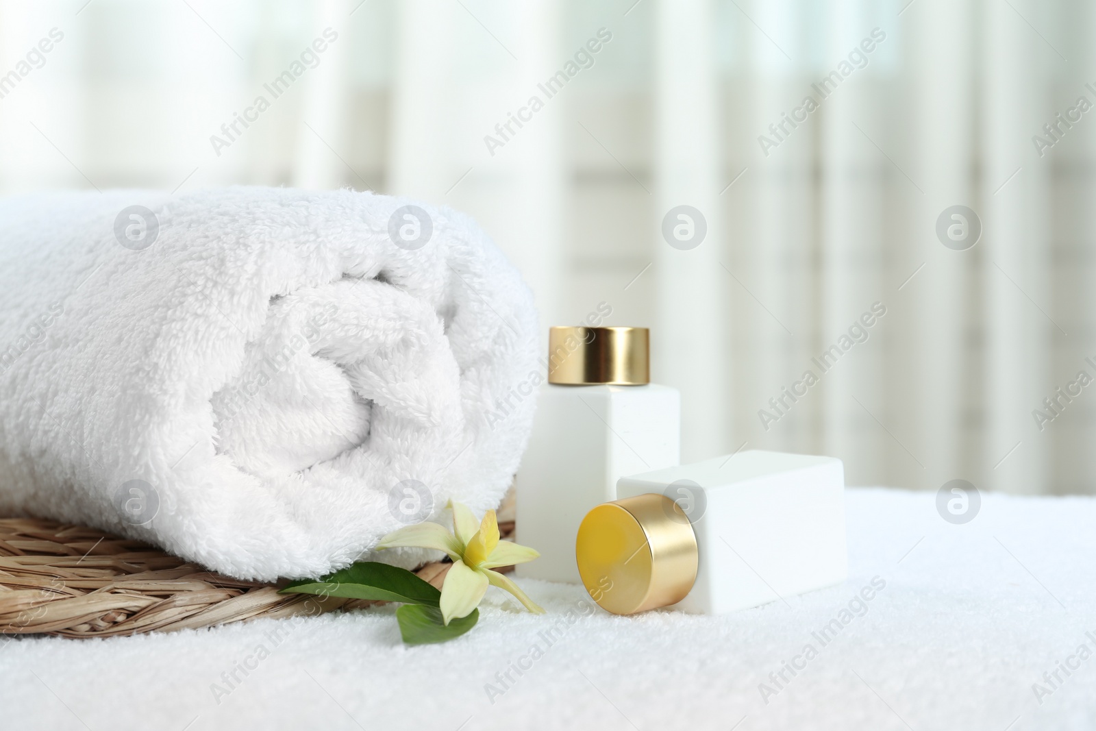 Photo of Composition with cosmetic products on white towel indoors, space for text. Spa therapy