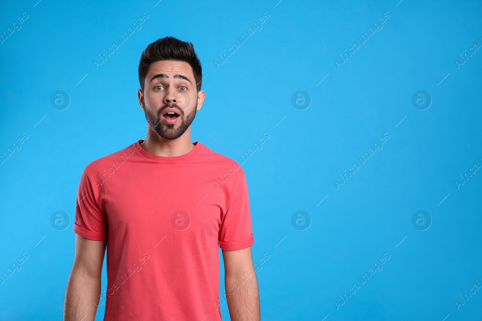 Photo of Emotional young man on light blue background, space for text. Thinking about difficult question