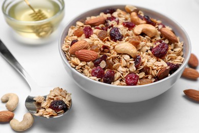 Photo of Tasty granola served with nuts and dry fruits on white marble table