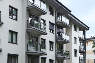 Photo of Exterior of white and black building with glass balconies