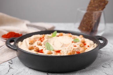 Delicious hummus with chickpeas and paprika served on white textured table, closeup