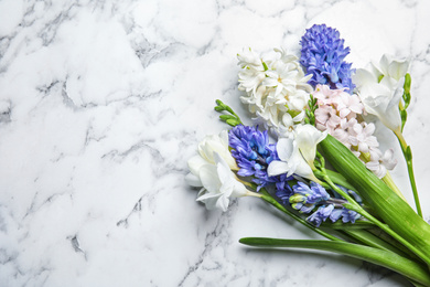 Beautiful spring flowers on white marble table, flat lay. Space for text