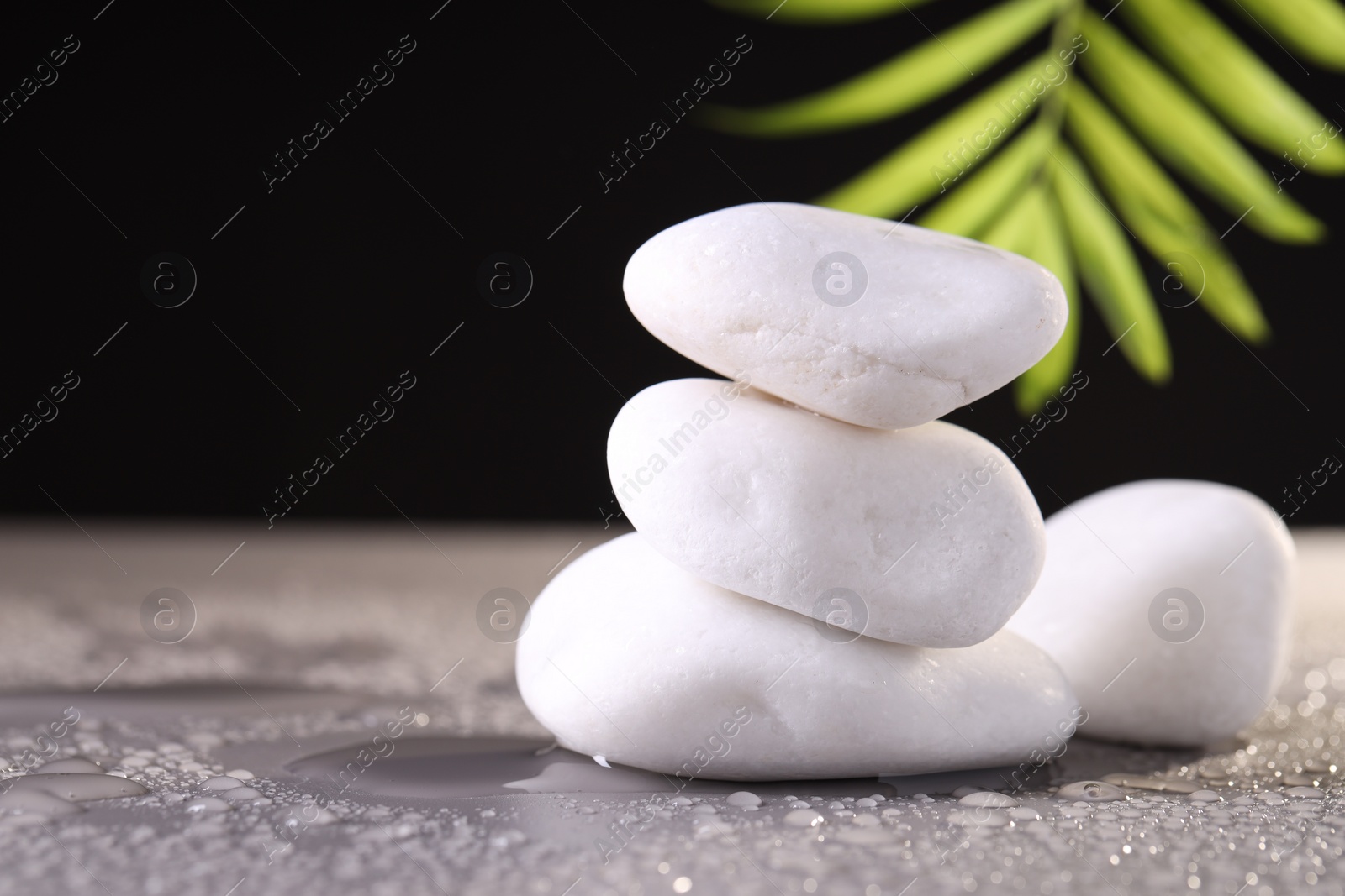 Photo of White spa stones with water drops on grey background. Space for text