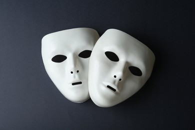 Photo of White theatre masks on black background, flat lay