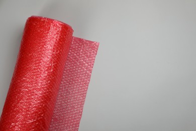 Photo of Bubble wrap roll on light background, top view. Space for text