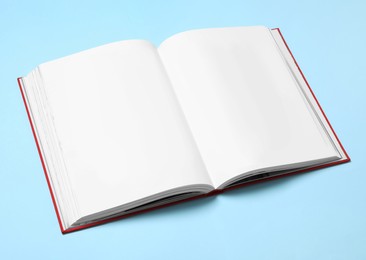 Photo of Open book with blank pages on turquoise background. Space for text