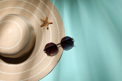 Stylish hat, starfish and sunglasses on light blue background, flat lay with space for text. beach objects