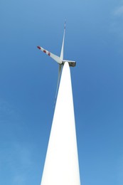 Modern wind turbine against blue sky, low angle view. Alternative energy source