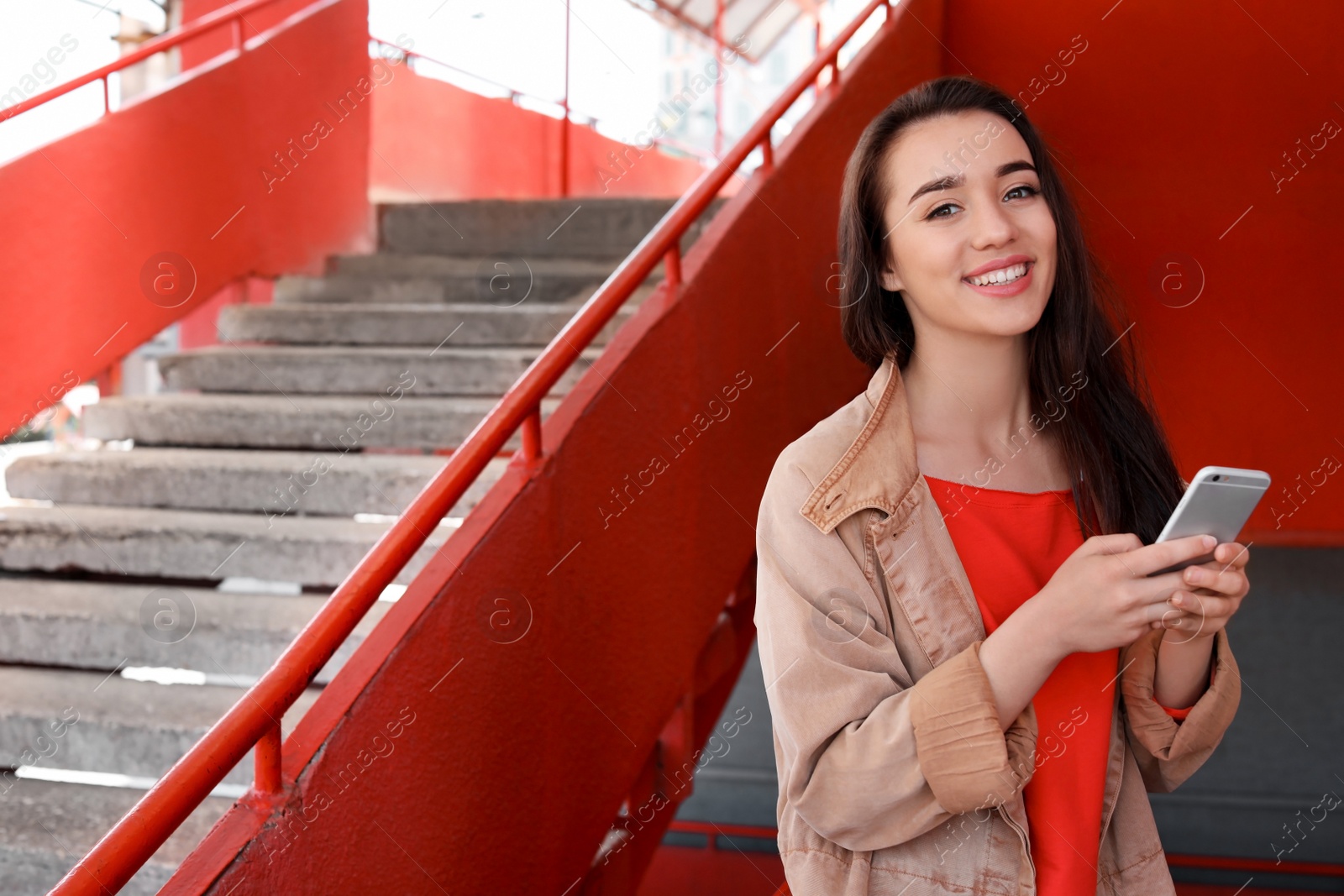 Photo of Young woman using mobile phone outdoors