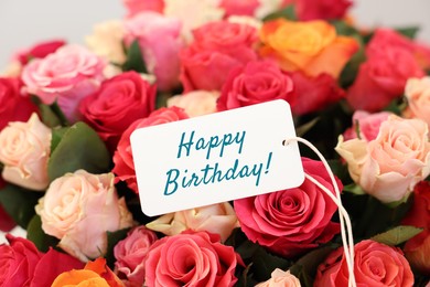 Image of Bouquet of beautiful roses with Happy Birthday card, closeup