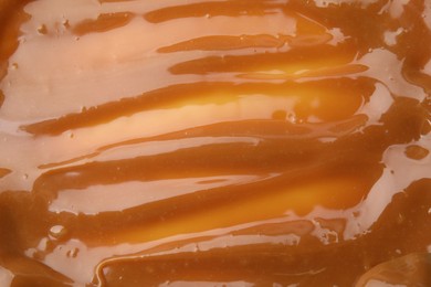 Delicious caramel sauce with sea salt as background, closeup