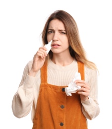 Photo of Sick young woman using nasal spray on white background