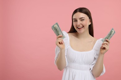 Photo of Happy woman with dollar banknotes on pink background, space for text