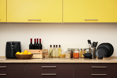 Photo of Stylish kitchen interior with wooden countertop and wall cabinets