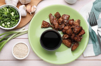 Photo of Tasty roasted meat, soy sauce and products on white wooden table, flat lay