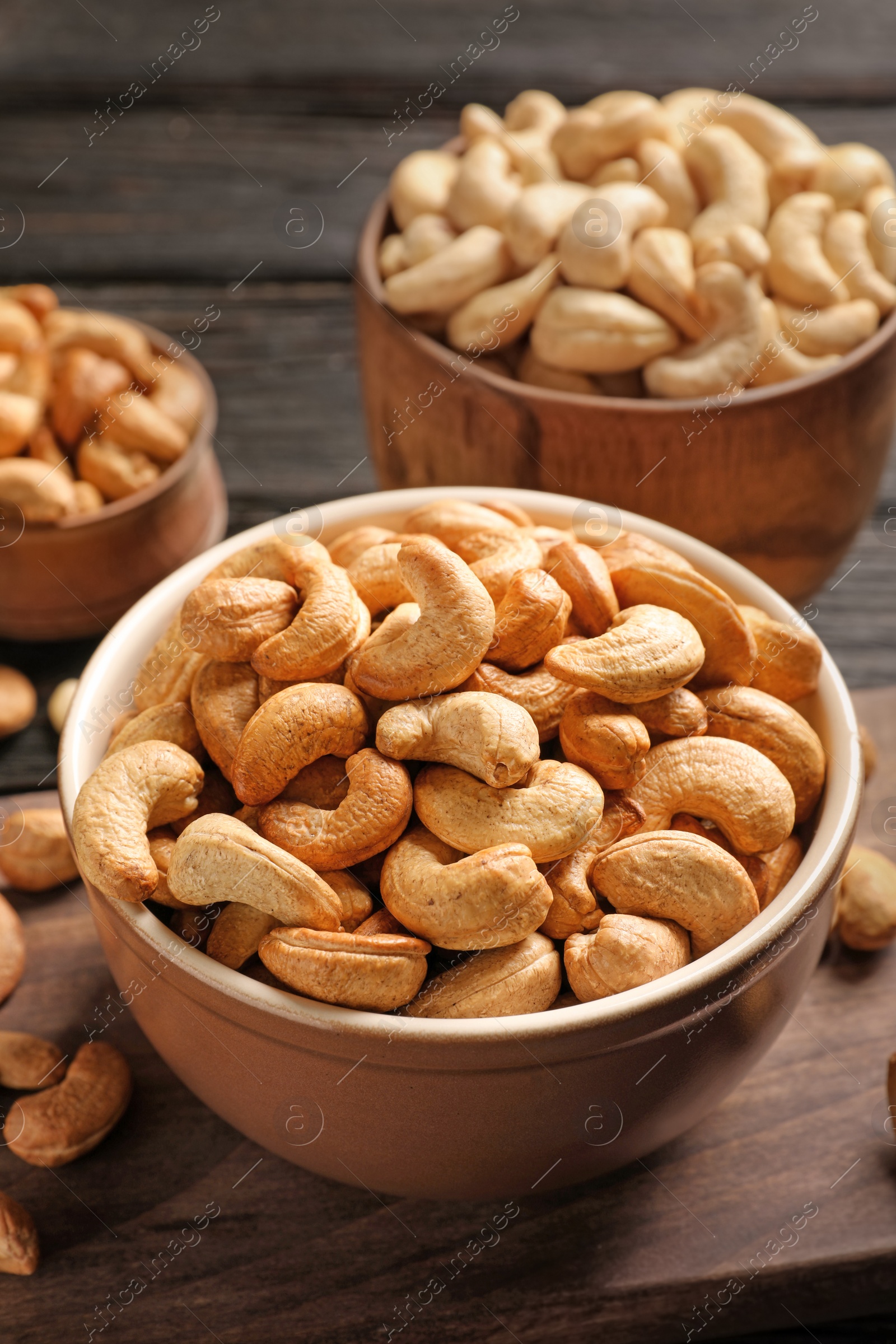 Photo of Bowl with cashew nuts on wooden table