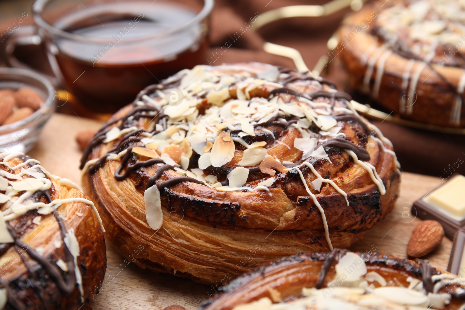 Photo of Delicious rolls with toppings and nuts on table, closeup. Sweet buns