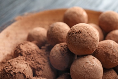 Photo of Plate with chocolate truffles on table, closeup