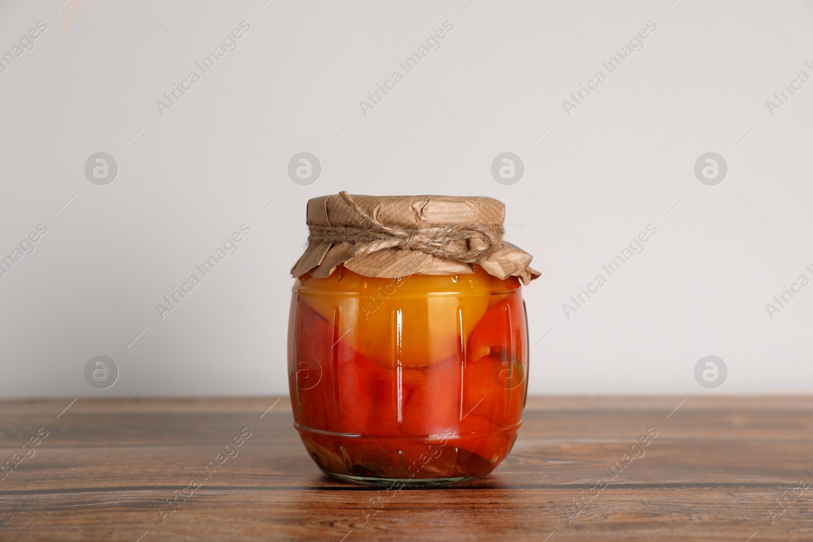 Photo of Jar with pickled bell peppers on wooden table