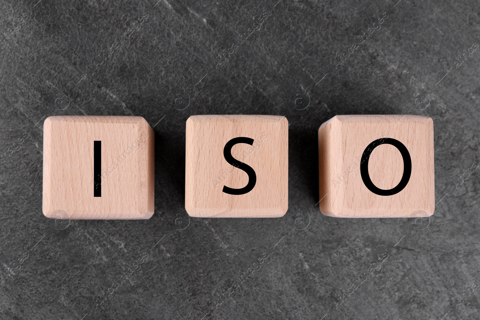 Photo of International Organization for Standardization. Cubes with abbreviation ISO on gray textured table, top view