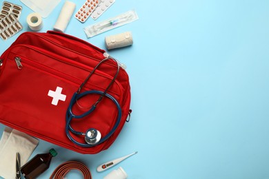 Photo of Flat lay composition with first aid kit on light blue background, space for text