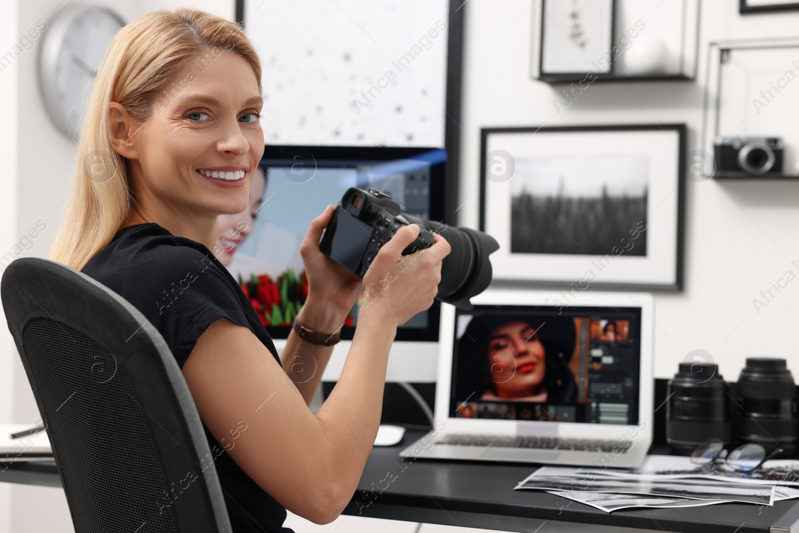 Photo of Professional photographer with digital camera at table in office