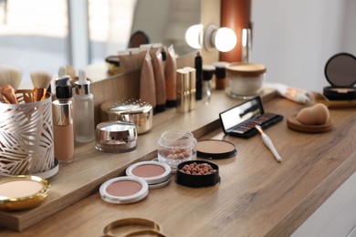 Photo of Many different cosmetic products on dressing table indoors