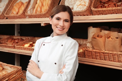 Portrait of professional baker near showcase in store