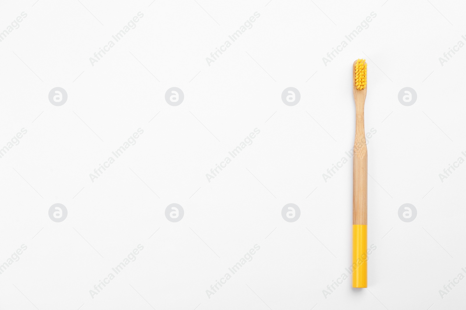 Photo of Bamboo toothbrush with yellow bristle isolated on white, top view