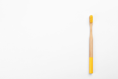 Bamboo toothbrush with yellow bristle isolated on white, top view