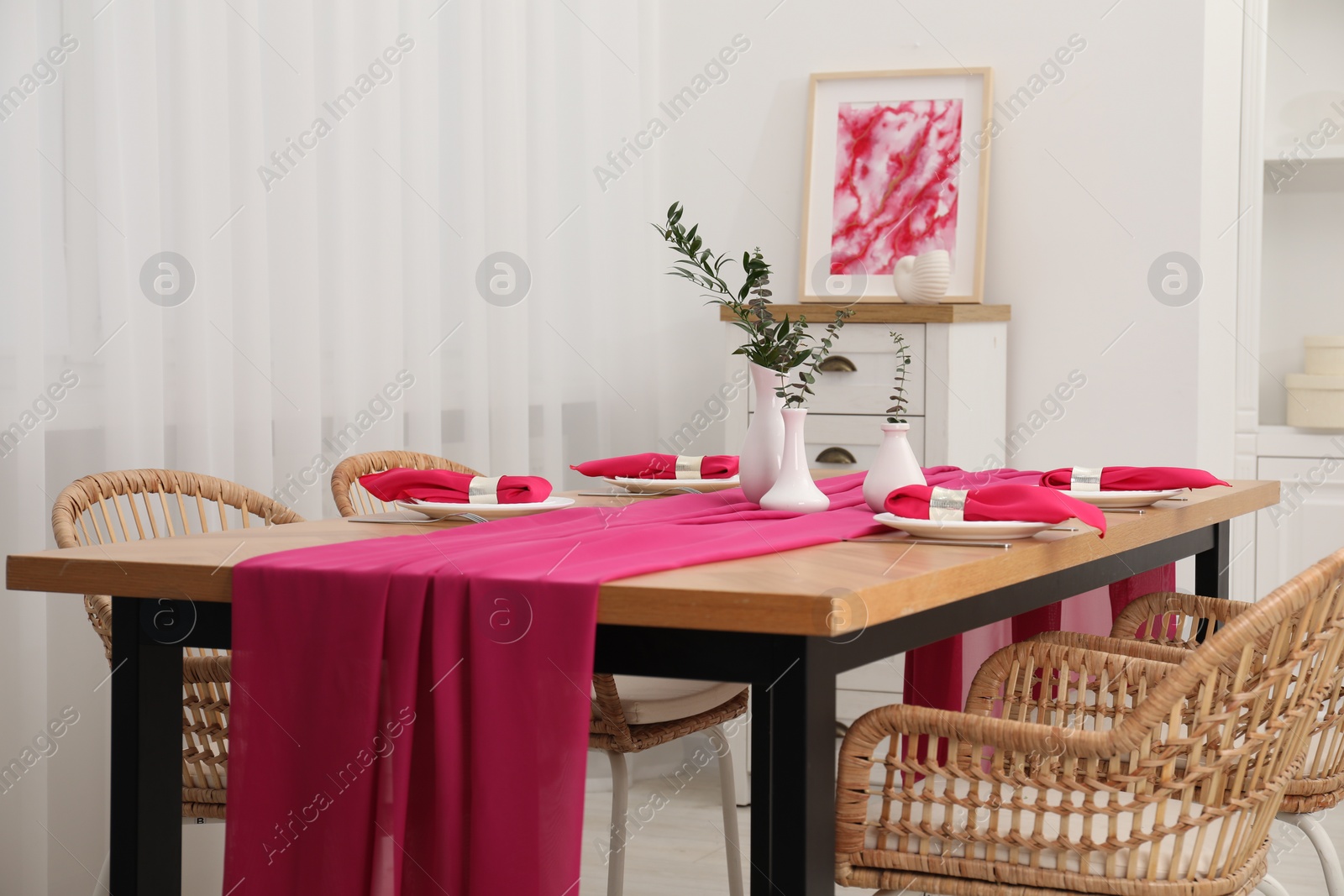 Photo of Beautiful table setting and vases with green branches in dining room