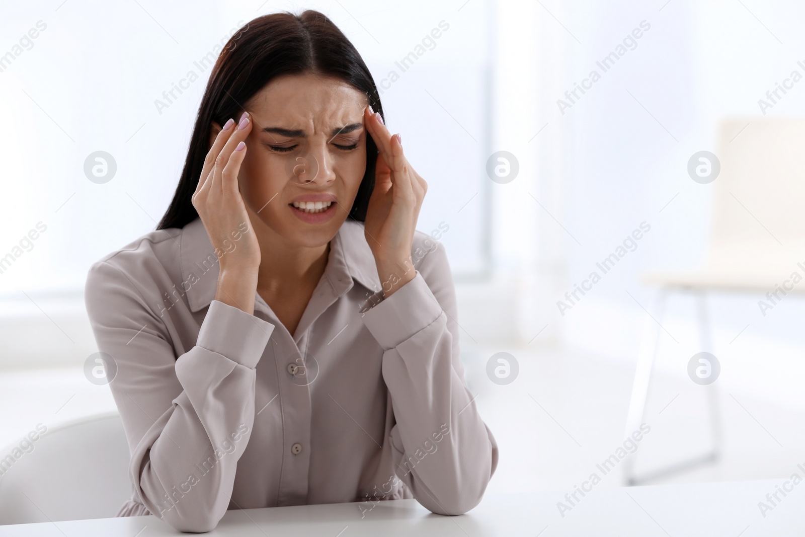 Photo of Stressed young woman at table in office