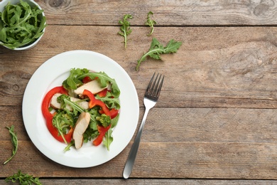 Photo of Delicious fresh chicken salad served on wooden table, flat lay. Space for text