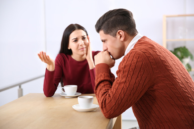 Photo of Couple having quarrel in cafe. Relationship problems