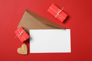 Photo of Flat lay composition with blank card on red background, space for text. Valentine's Day celebration