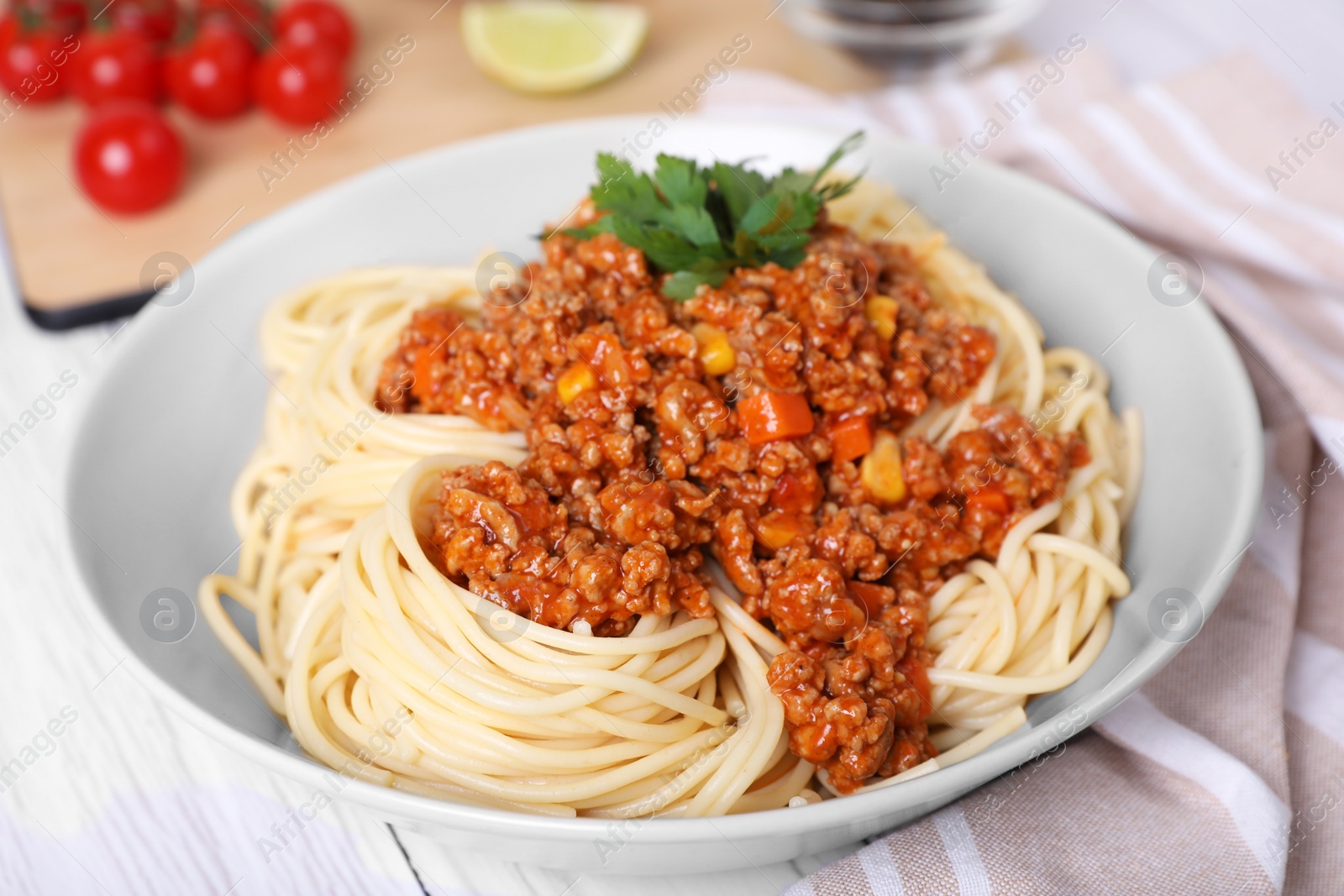 Photo of Tasty dish with fried minced meat, spaghetti, carrot and corn on white wooden table, closeup