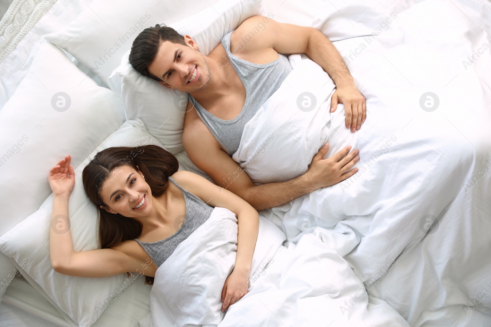 Photo of Lovely young couple resting in large bed, above view
