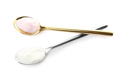 Spoons with different yogurts on white background