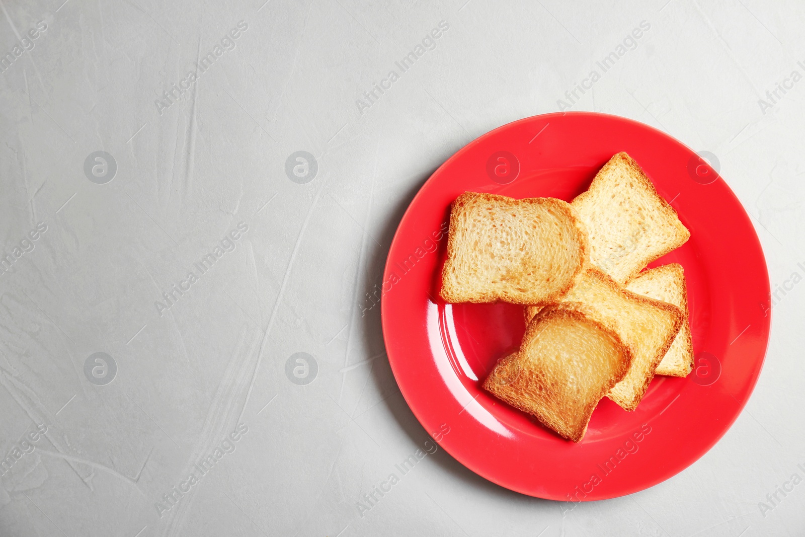 Photo of Plate with toasted bread on grey background, top view