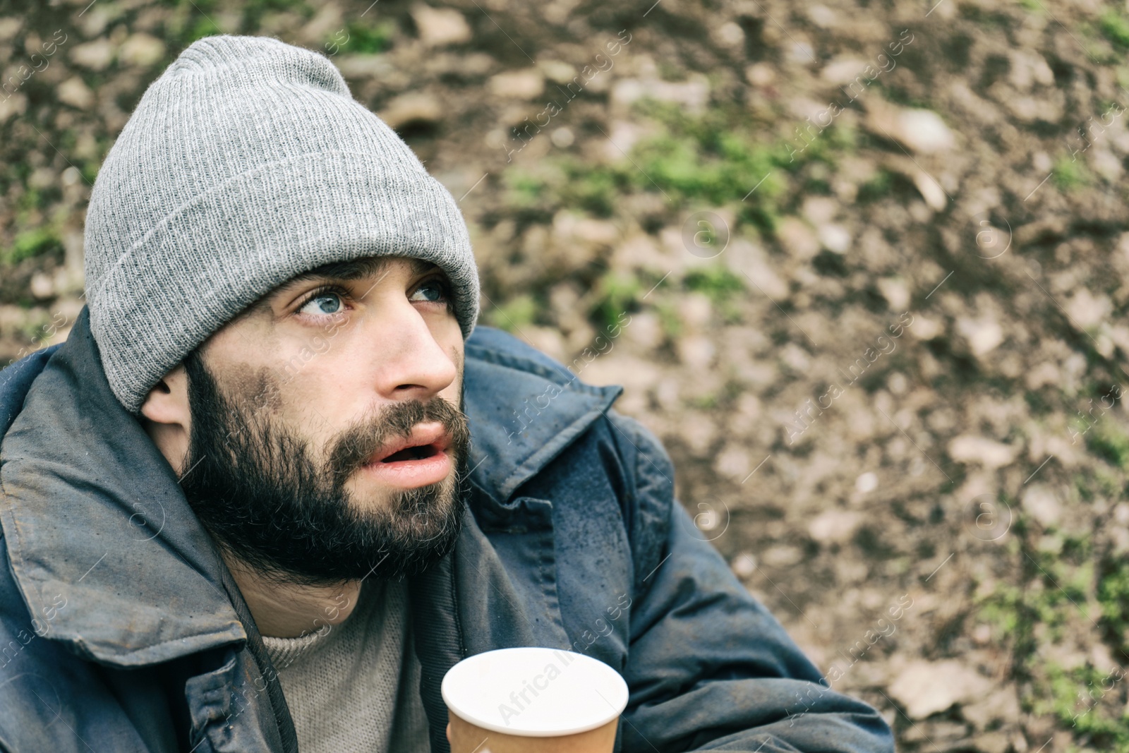 Photo of Poor homeless man with cup in city park