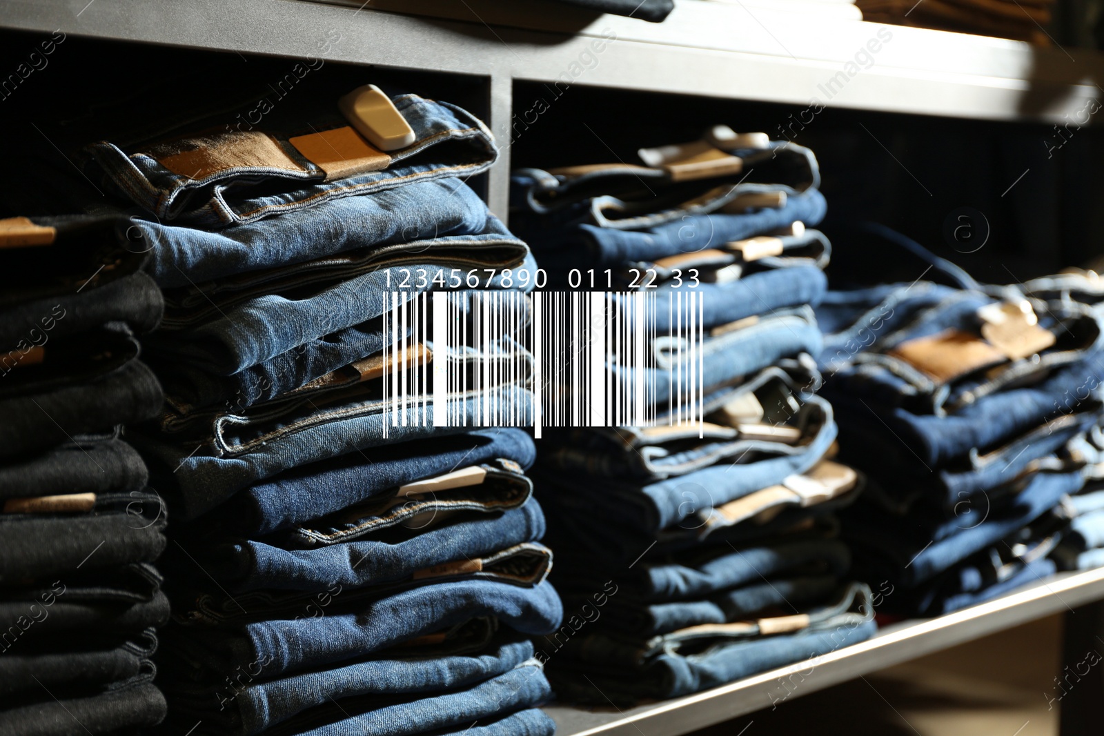 Image of Barcode and collection of stylish jeans on shelf in wholesale shop